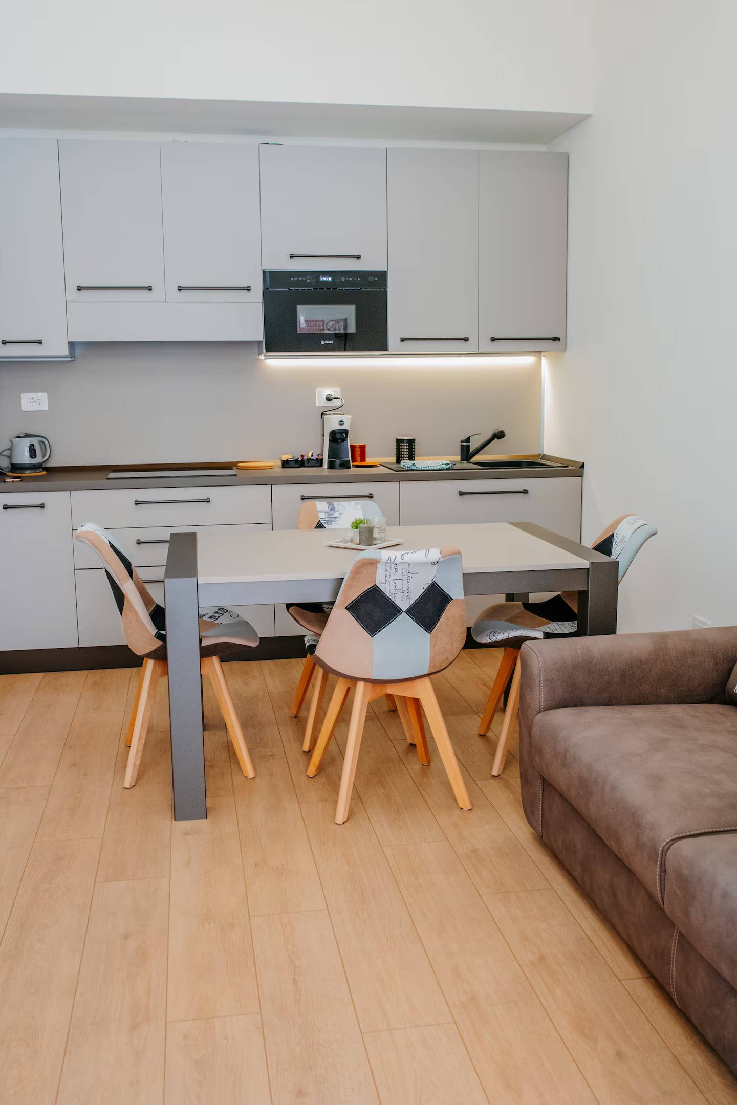 Cucina aperta sulla zona pranzo con tavolo, luce naturale dalla finestra — l'open space di Casa Nausicaa