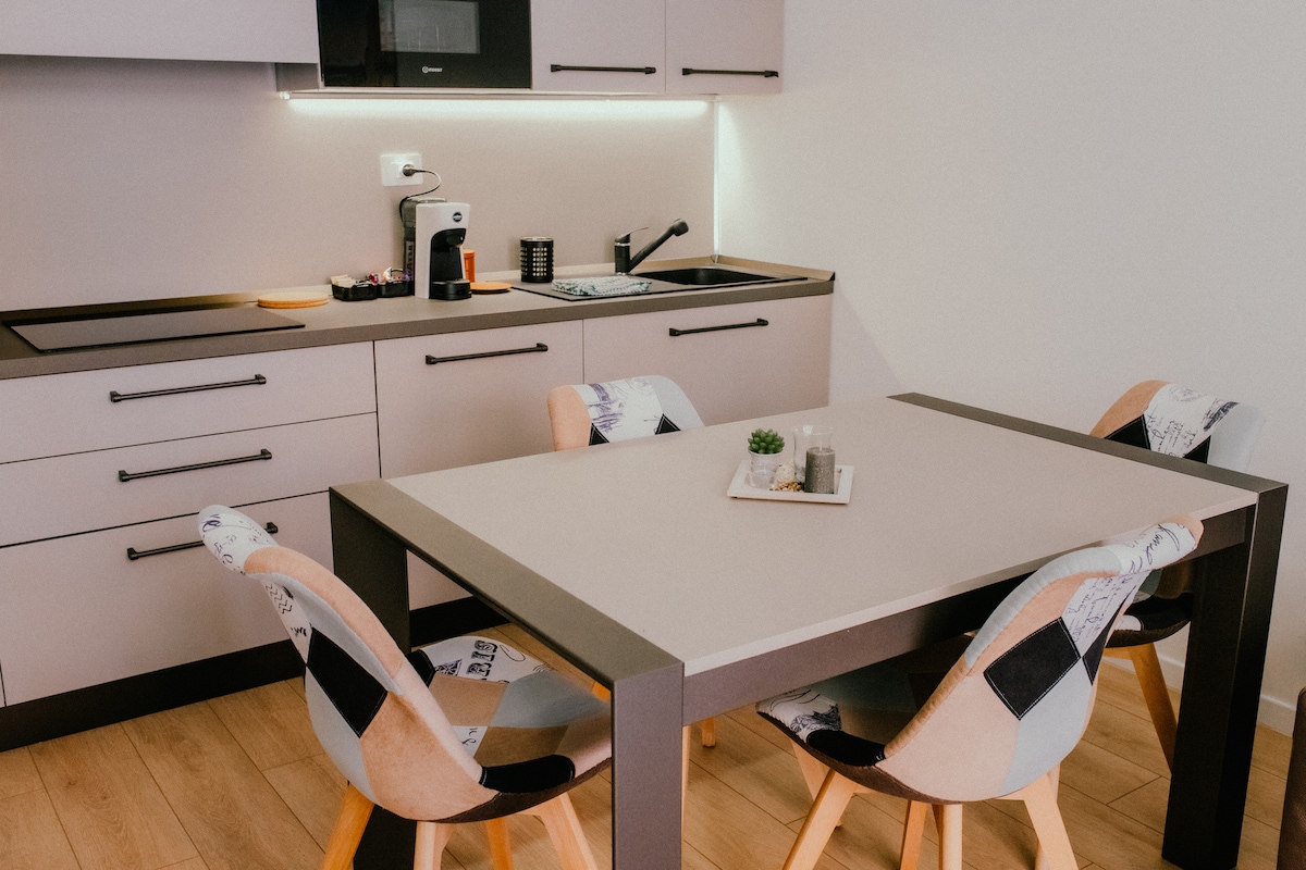 Tavolo da pranzo e cucina attrezzata con piano a induzione